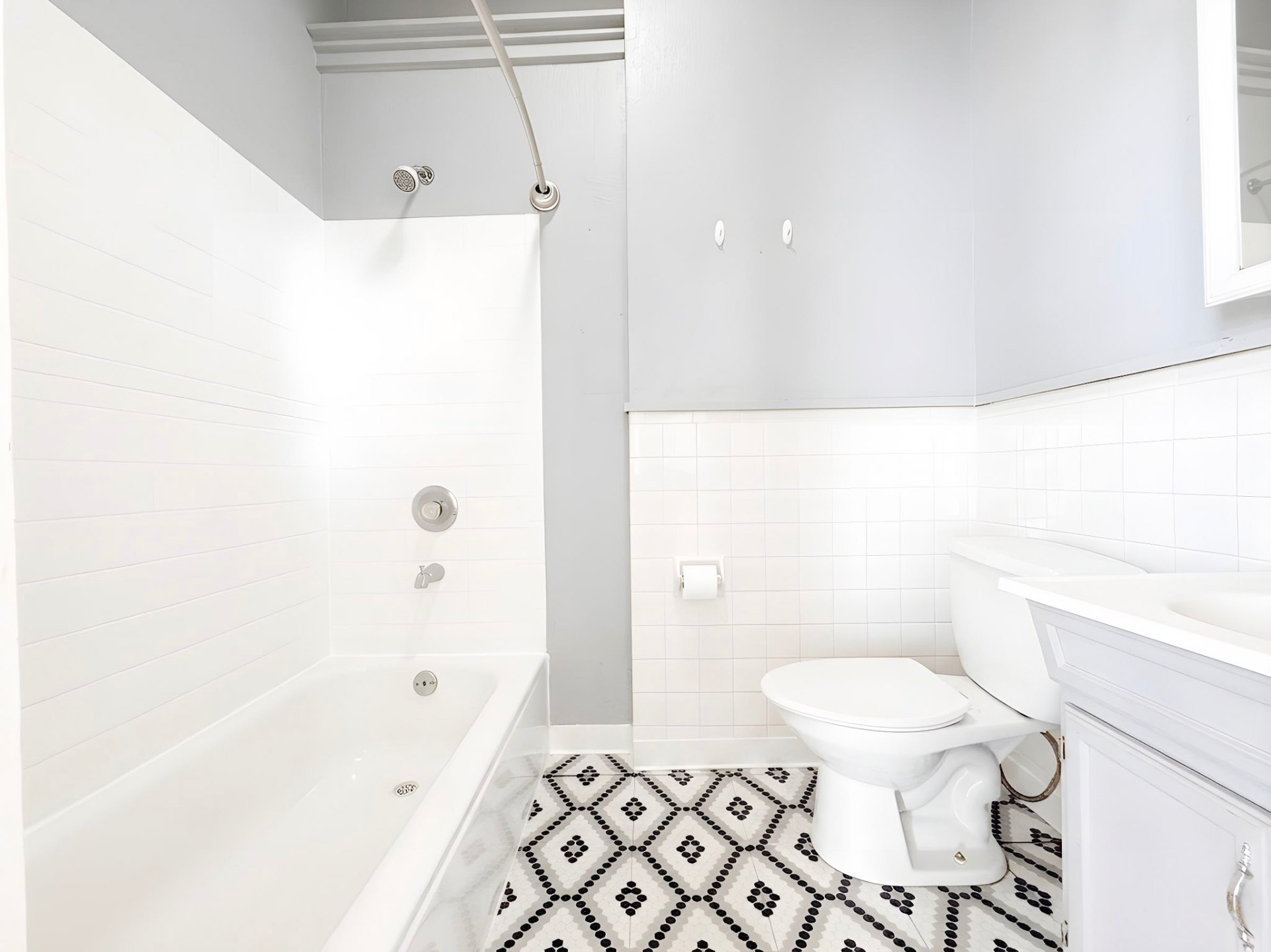 42 East Broadway — full bathroom with patterned tile floor